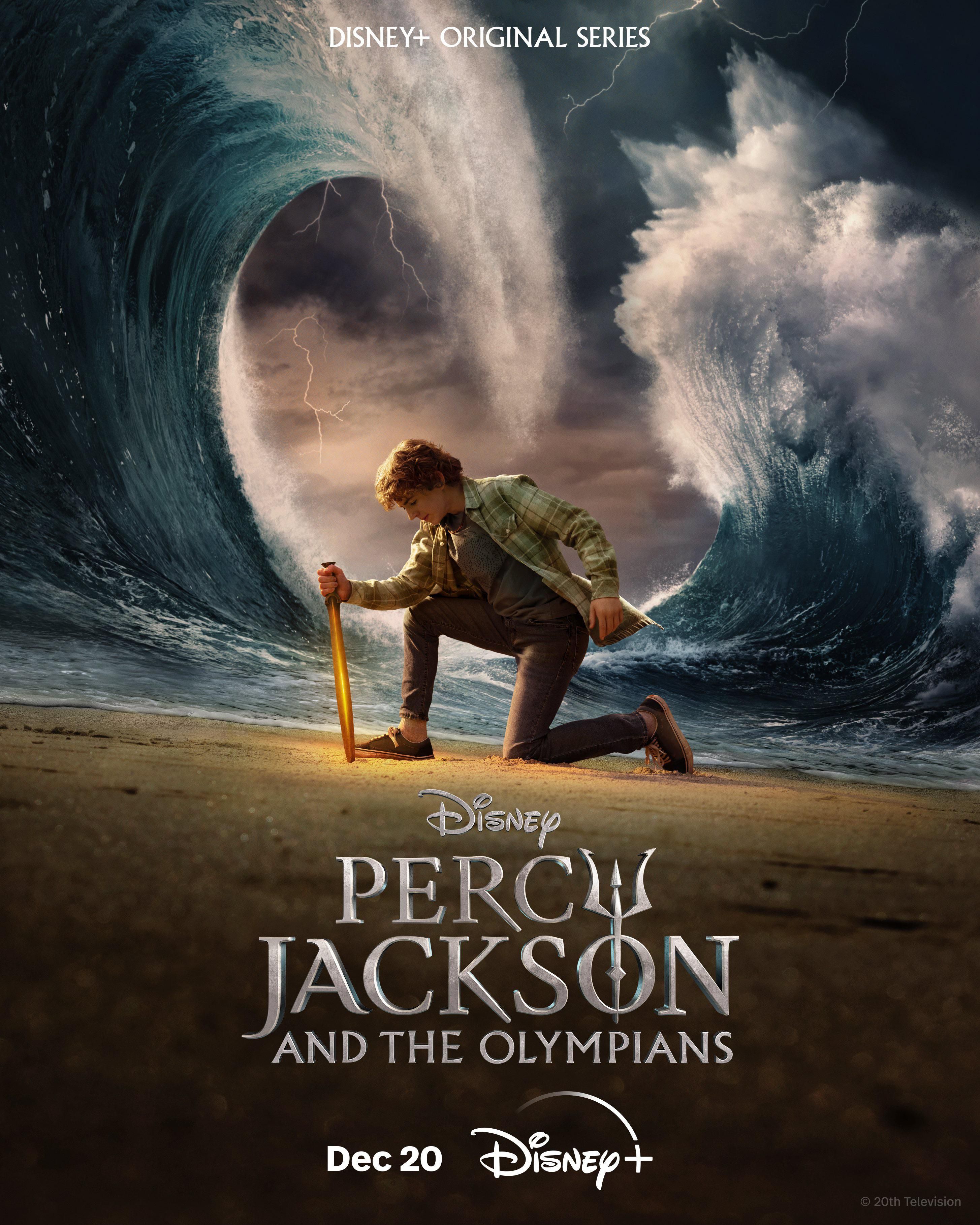 Walker Scobell in rolul lui Percy Jackson, tinand o lama in nisip in timp ce valuri masive se ridica in jurul lui intr-un poster pentru Percy Jackson si olimpienii.